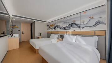Ett hotellrum med två sängar, en stor väggmålning, ett skrivbord med en stol och en spegel.
