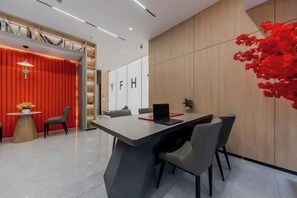 A modern office space with a long table, chairs, and a laptop. - YUE FEI YUN Hotel (Shanghai)