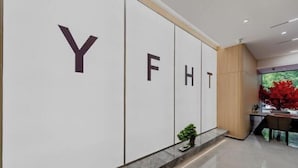 Un área de recepción con una pared que muestra grandes letras 'Y FHT'.