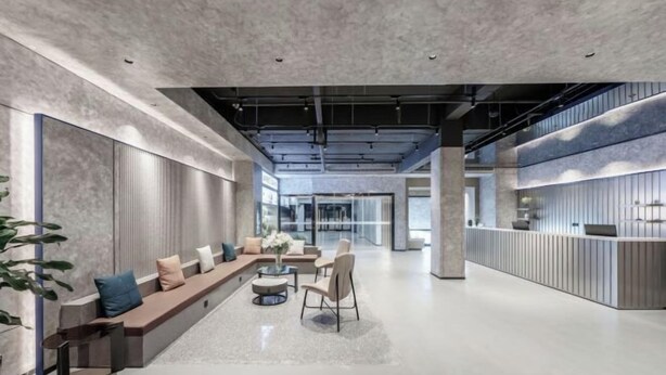 Un vestíbulo amplio con zona de estar, mostrador de recepción y diseño moderno.