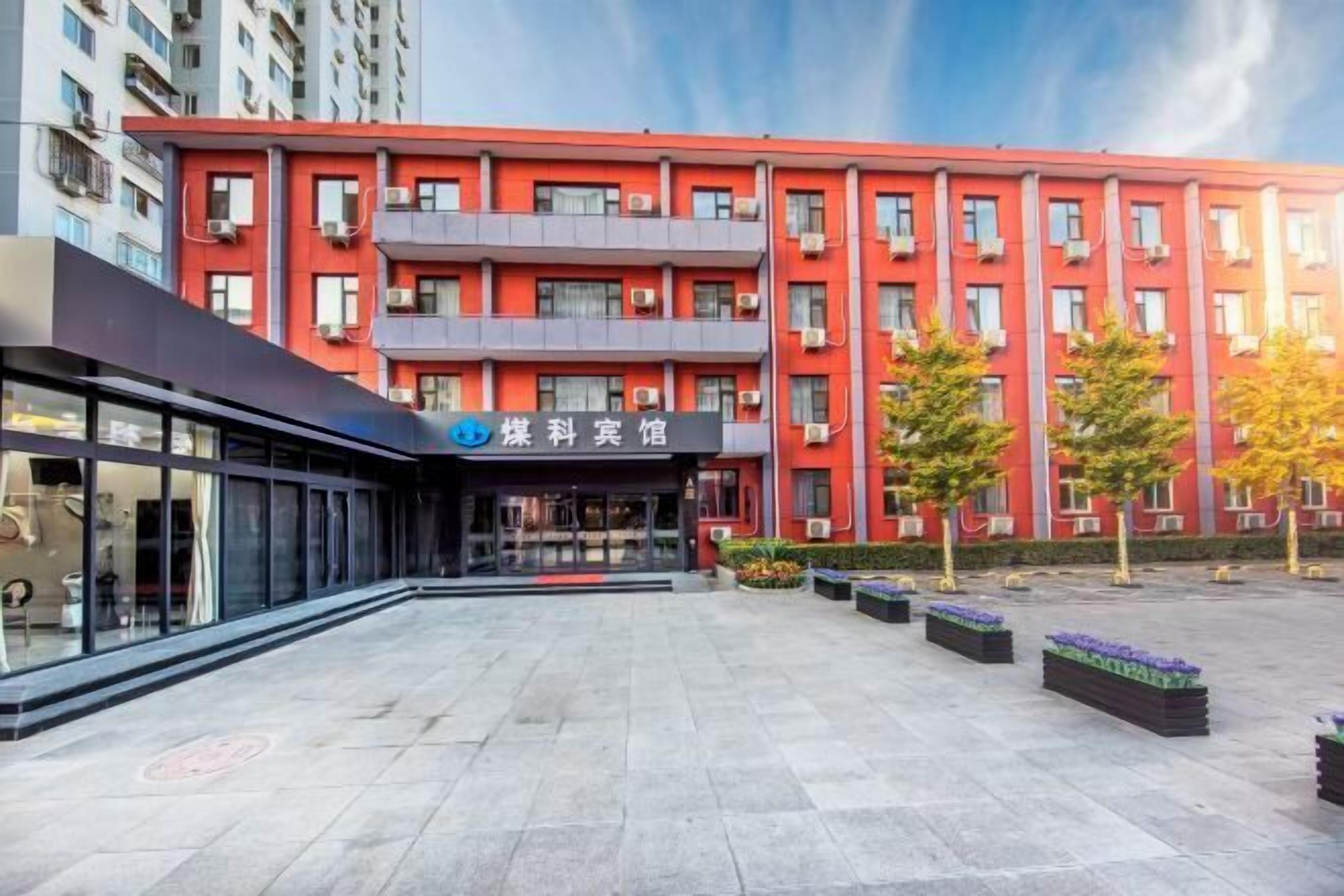 A multi-story building with a red facade and a modern entrance.