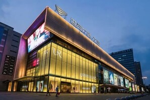 A modern building with large glass windows and a prominent sign. - TRUE GO Hotel (Chaoyangmen Subway Station, Beijing Workers' Stadium) (Beijing)