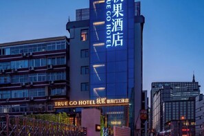 Un edifici de diversos pisos amb indicadors per 'TRUE GO HOTEL' i 'True Go Hotel'.