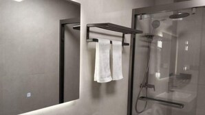 A modern bathroom with a glass-enclosed shower, a visible toilet, and a towel rack with two towels. - Zhulian Hostel (Wenzhou)