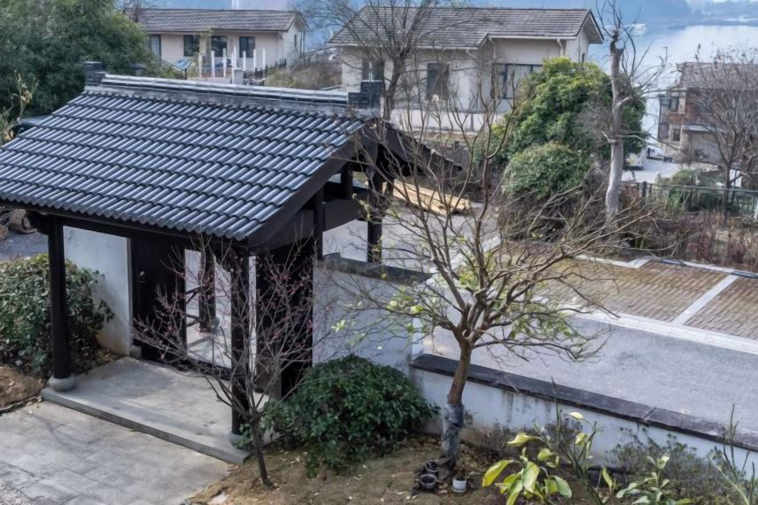 Un edificio tradicional japonés con tejado de tejas y un pequeño jardín.