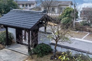 Un edificio tradicional japonés con tejado de tejas y un pequeño jardín.