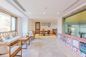 A hotel lobby with a reception desk, seating area, and a large window.