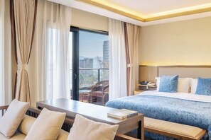 A hotel room with a bed, a desk, a chair, and a view of the city. - Banmeiju GINLAN JIA Vacation Apartment (Jiande)