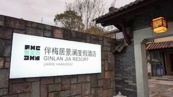 Cartell del Jinlan Jia Resort, amb mur de maó i elements arquitectònics xinesos tradicionals.