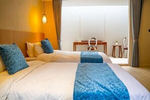 Ein Hotelzimmer mit zwei Betten, einem Schreibtisch und Blick ins Freie.