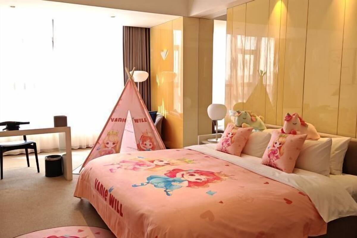 Un dormitorio con una cama, almohadas, un escritorio y una silla.