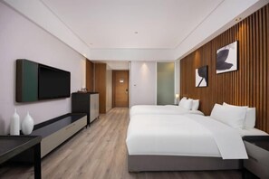 A modern hotel room with a large bed, a flat-screen TV, a wooden accent wall, and a minimalist design.