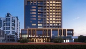 A modern hotel building with multiple floors, large windows, and a well-lit entrance. - Wanda Yue,Huaian Hongze Lake (Huai'an)
