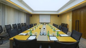 A conference room with a long table, chairs, a projector screen, and a whiteboard. - Wanda Yue,Huaian Hongze Lake (Huai'an)