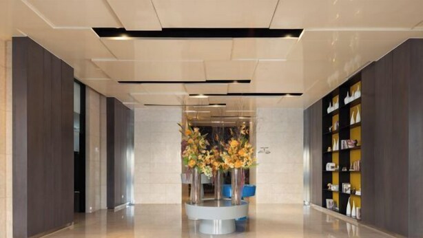 A modern lobby with a central floral arrangement, a bookshelf, and a polished floor. - Wanda Yue,Huaian Hongze Lake (Huai'an)
