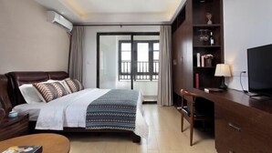 Una camera d'albergo con un letto, una scrivania, una sedia, una televisione e una libreria.