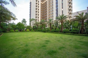 A grassy courtyard with a high-rise building in the background.