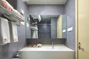 A modern bathroom with a large mirror, a sink, and a shower area. - suyu hotel (Taiyuan)