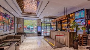 A hotel lobby with seating, a reception desk, and a large window. - Gujia Hotel (Xinxiang)