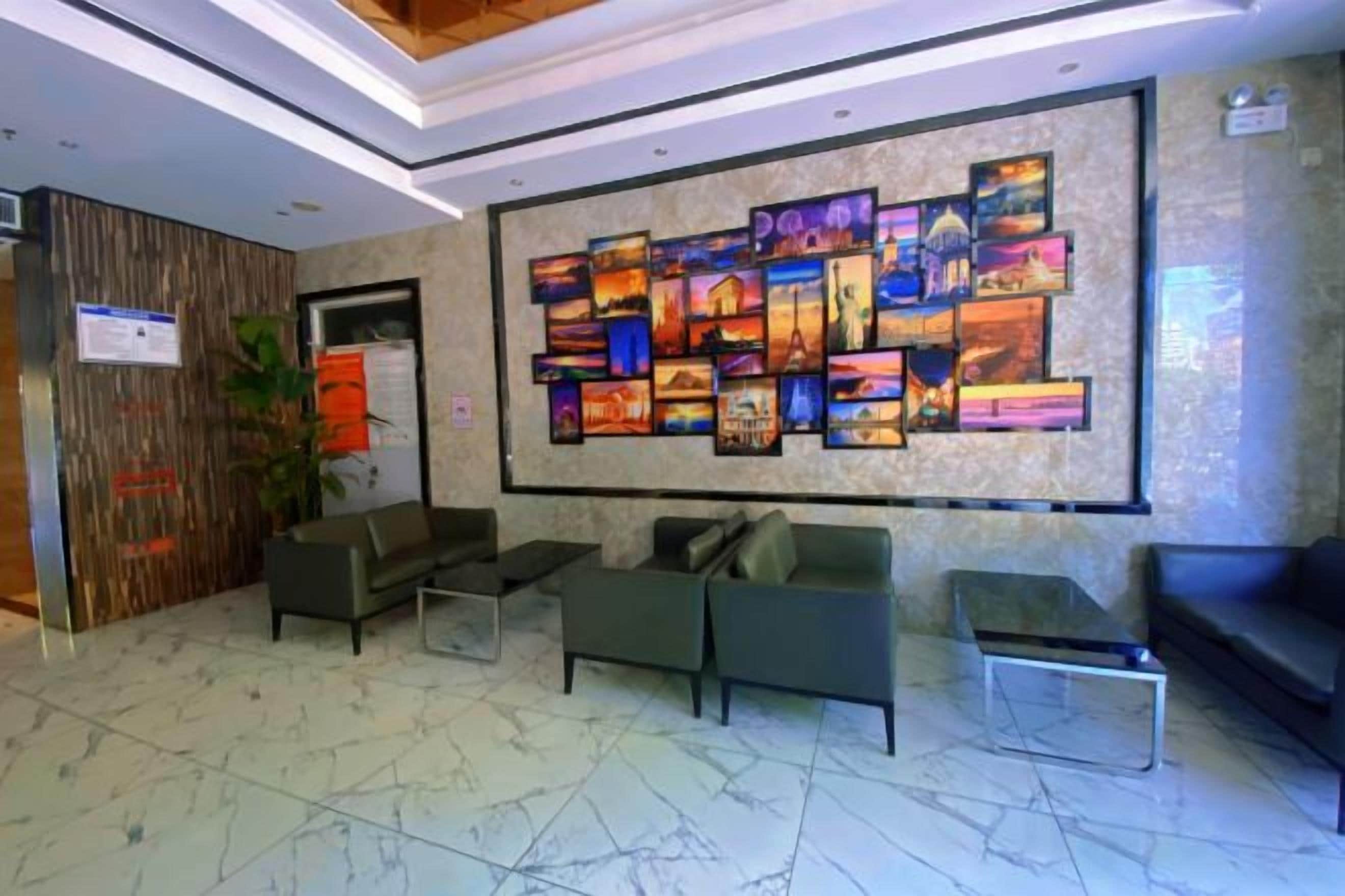 Un hall con un gran mural, una zona de estar y un mostrador de recepción.