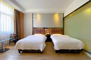 Habitación de hotel con dos camas, un escritorio y una silla.