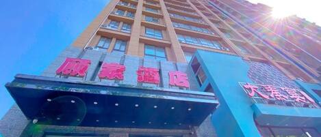 A multi-story hotel building with a prominent entrance and signage.