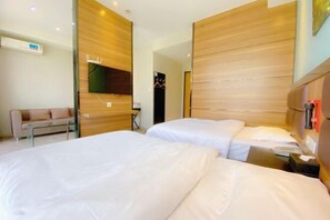 A hotel room with two beds, a sofa, and a wooden headboard. - Gujia Hotel (Xinxiang)
