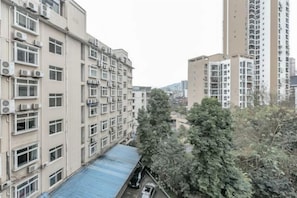 Un edificio residencial de varios pisos con balcones y una estructura de techo azul en primer plano.