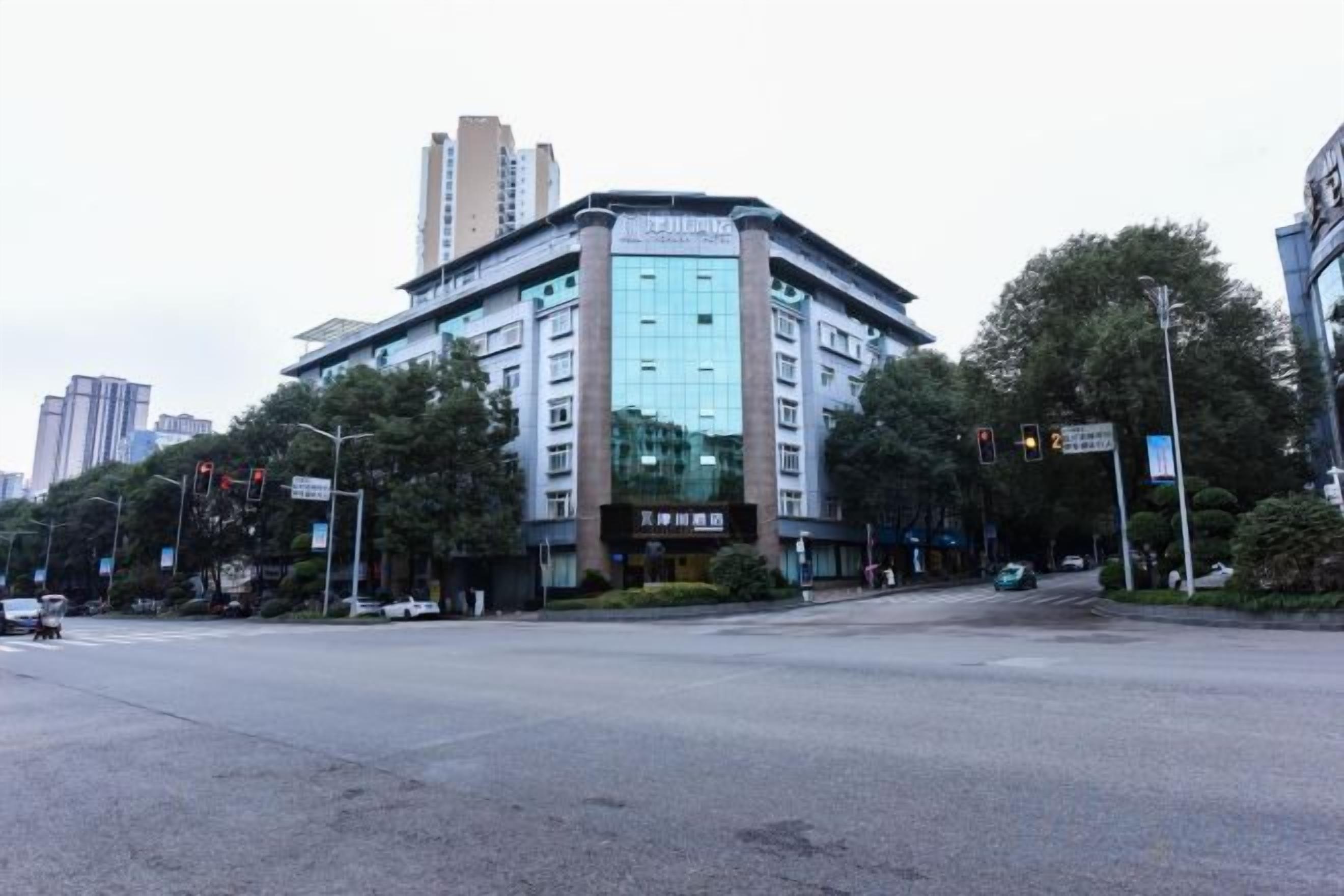 A multi-story hotel with a modern design, located at a city intersection.