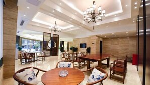 A spacious dining area with wooden tables and chairs, recessed ceiling lighting, and a view of the outdoors. - Chongqing Jinchuan Hotel (Chongqing)
