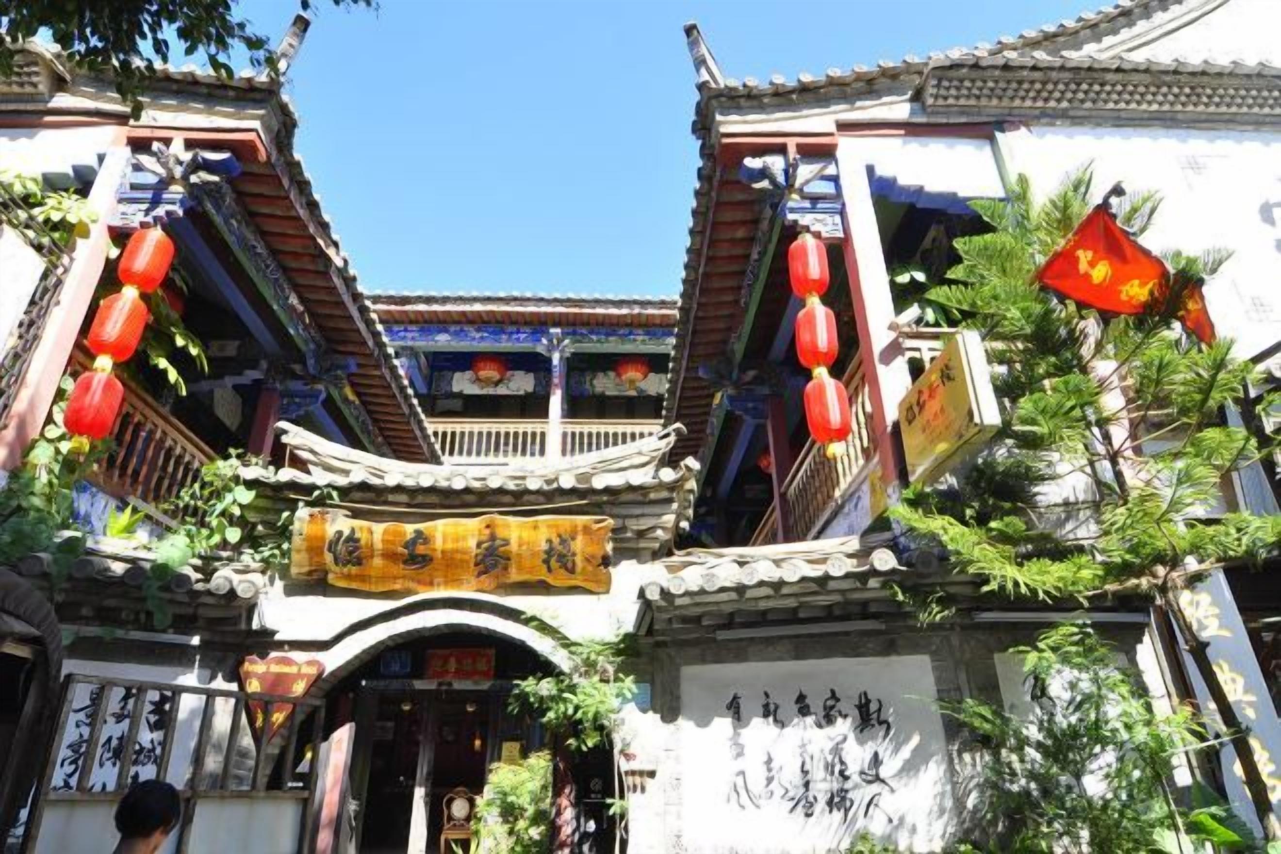 Un edificio tradicional con techo de tejas, faroles rojos y un letrero con caracteres chinos.