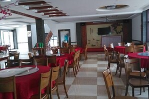 A dining area with multiple tables and chairs, some with red tablecloths, and a checkered floor pattern. - Jing Taohua Jie Holiday Homestay (Taohua Tan Scenic Area) (Jing County)