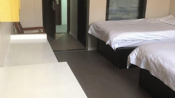 Ein modernes Hotelzimmer mit einem Bett, einem Schreibtisch und einem Sessel.