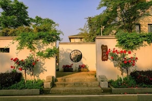 A building entrance with steps, a circular window, and a wall with a sign.