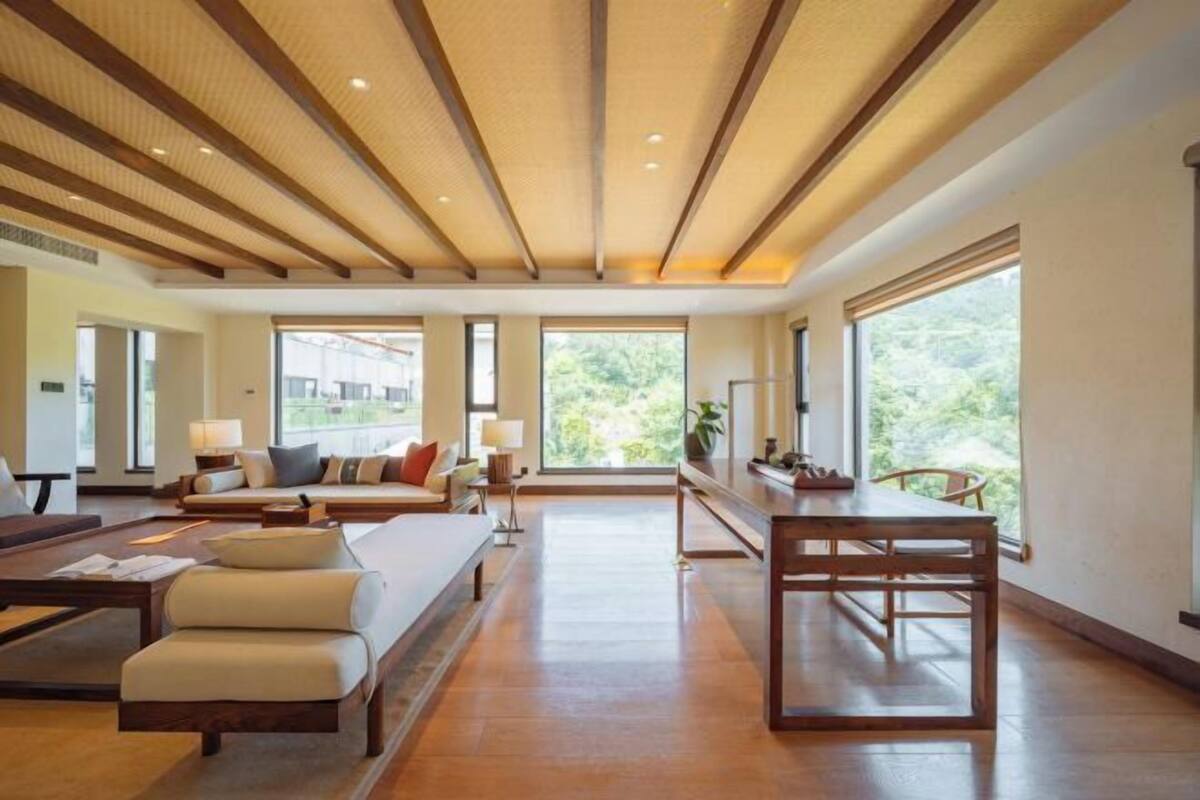 Un salón amplio con techos altos, ventanas grandes, una mesa de comedor de madera y asientos cómodos.