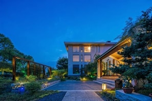 A modern building with a central courtyard, surrounded by greenery and potted plants.