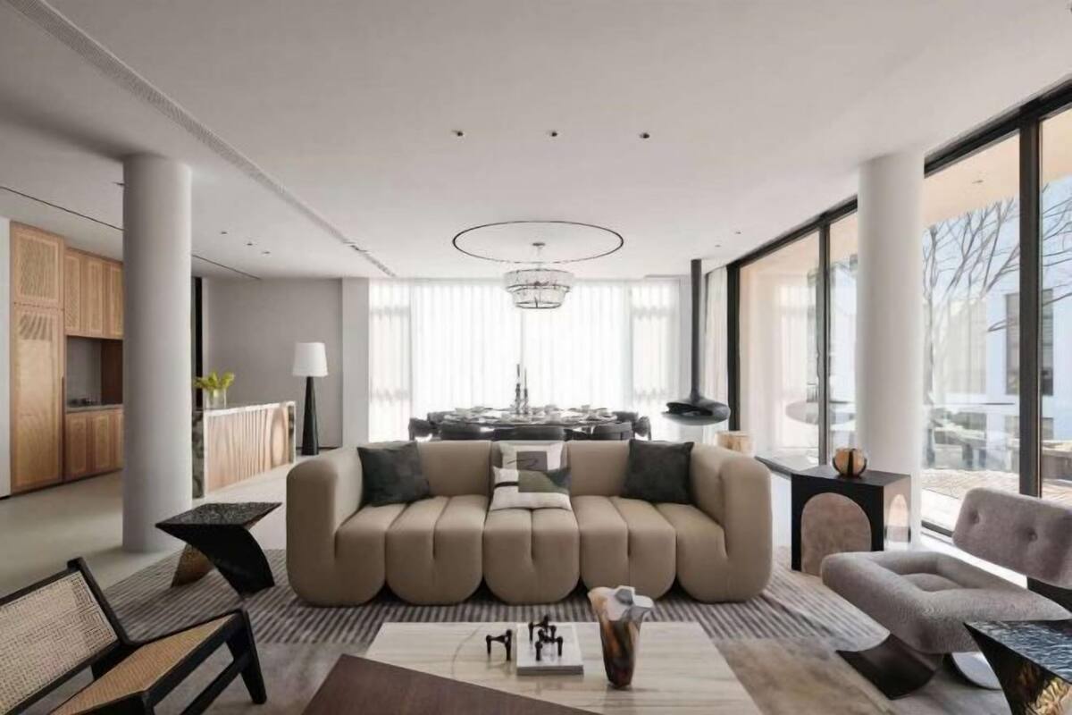 Una sala de estar moderna con un sofá, una mesa de centro y un comedor al fondo.