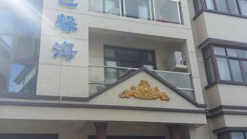 Un edificio con un balcón y un cartel con caracteres chinos.