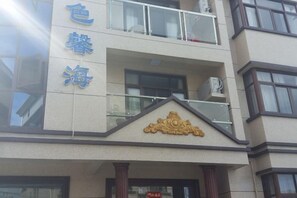 A building with a balcony and a sign with Chinese characters.