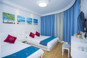A hotel room with two beds, a small table, a TV, and artwork on the wall. - Blue Xinhai Homestay (Shengsi)