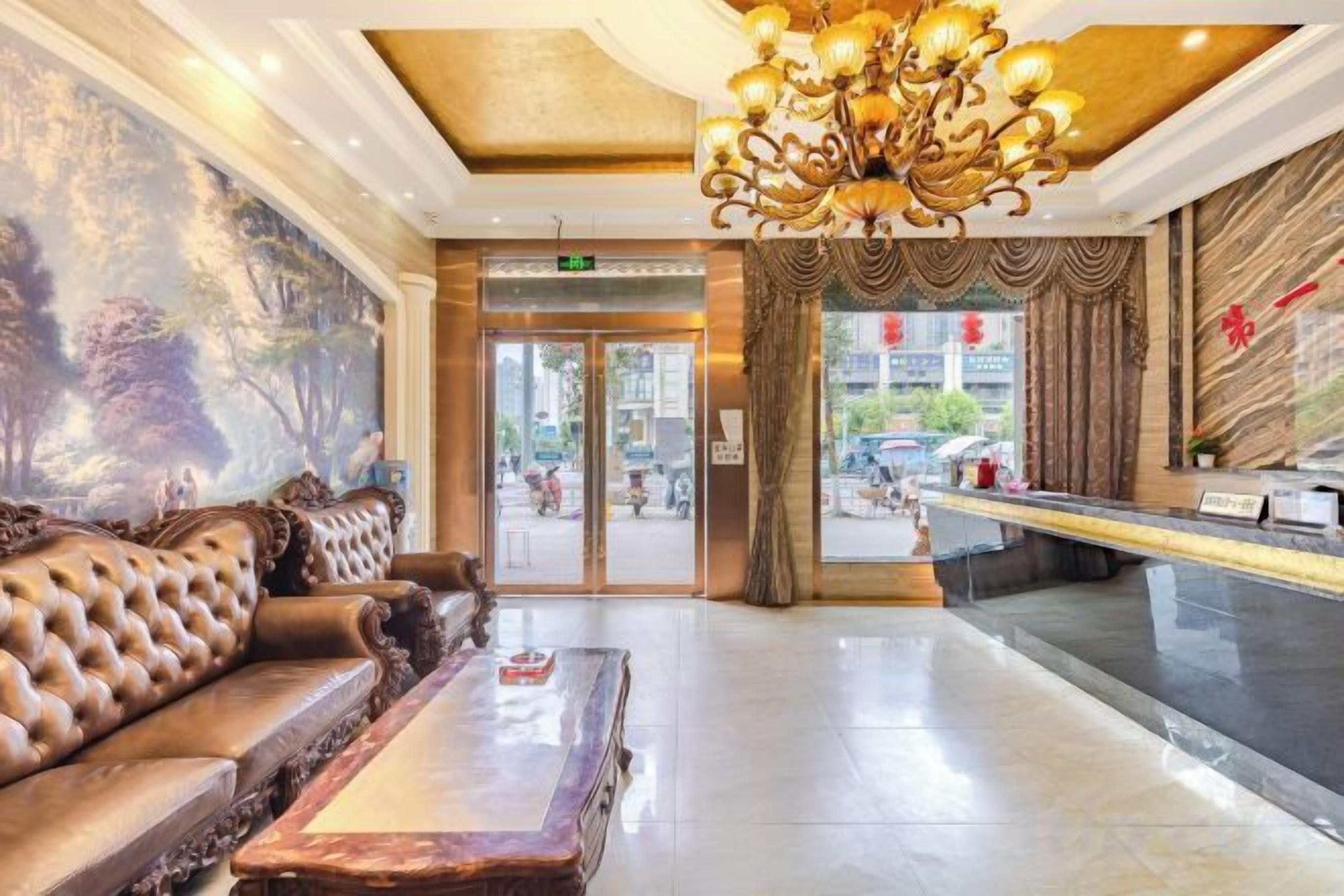 A lobby with a reception desk, a sofa, and a chandelier.
