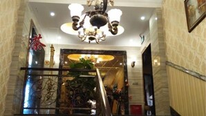 A grand staircase with a chandelier, a decorative railing, and a sign with Chinese characters.