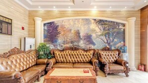 A luxurious living room with a large, ornate sofa set, a marble coffee table, and a mural of a forest scene on the wall.