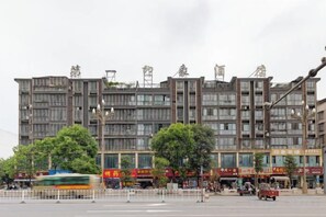 Un edificio de varios pisos con una planta baja comercial, que incluye escaparates y un paseo peatonal.