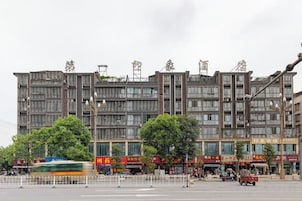 Edifício de vários andares com um andar comercial na parte inferior, com lojas e uma passarela para pedestres.