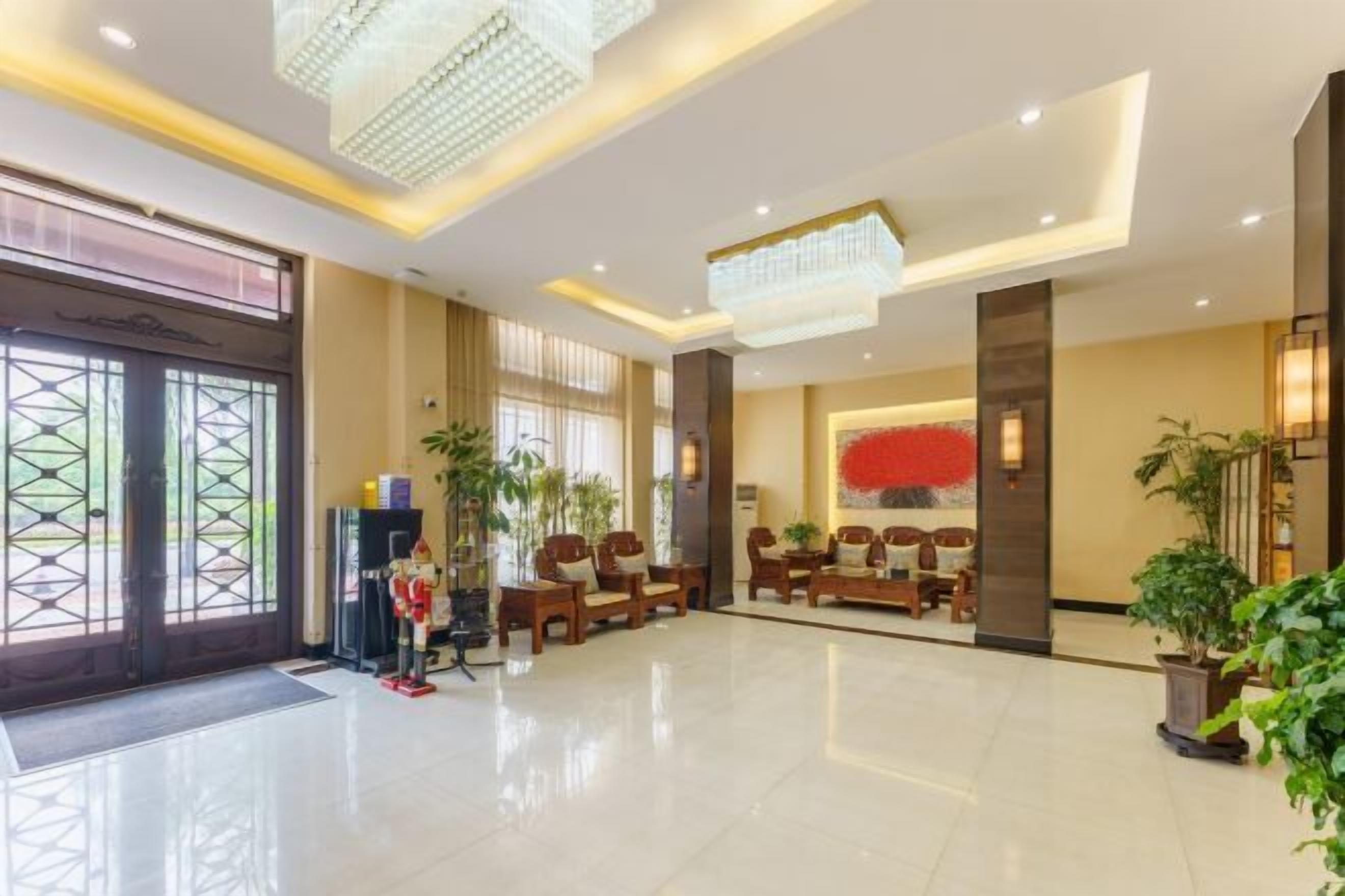 A spacious lobby with a reception desk, seating area, and large windows.