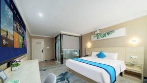 Een hotelkamer met een bed, nachtkastje, bureau, stoel en een televisie.