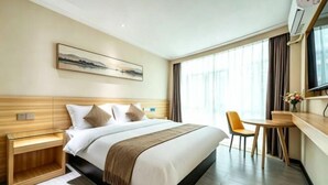A hotel room with a bed, bedside table, chair, and a painting on the wall. - Kaimei Convenience Hotel (Nanning Jinxiang Avenue Subway Station) (Nanning)