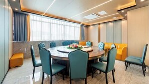 A modern conference room with a round table, teal chairs, and a sofa. - Kaimei Convenience Hotel (Nanning Jinxiang Avenue Subway Station) (Nanning)