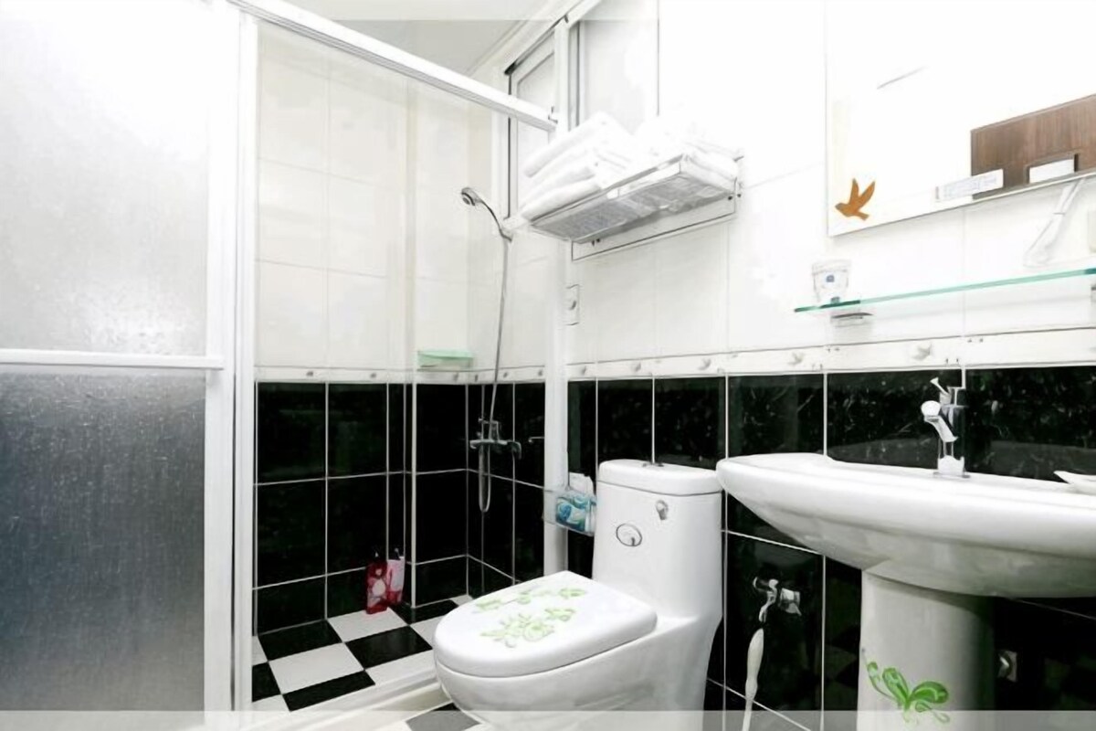 A bathroom with a toilet, sink, and shower.